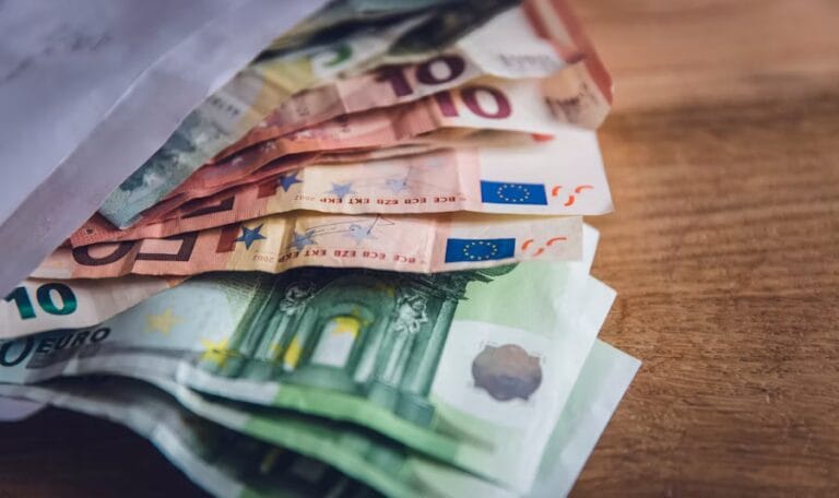 Euro banknotes placed on a wooden surface, symbolizing business finance, investment, and tax compliance.