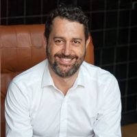 Professional portrait of David Gordillo, a satisfied Legal Hunt client, smiling in a business setting.