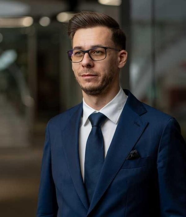 Laurențiu Asaftei – Expert in Business Law and Co-Founder Professional portrait of Laurențiu Asaftei, co-founder of Legalhunt, wearing a tailored blue suit and glasses, exuding confidence and expertise.