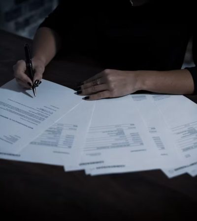 Person reviewing and signing market transaction documents on a desk
