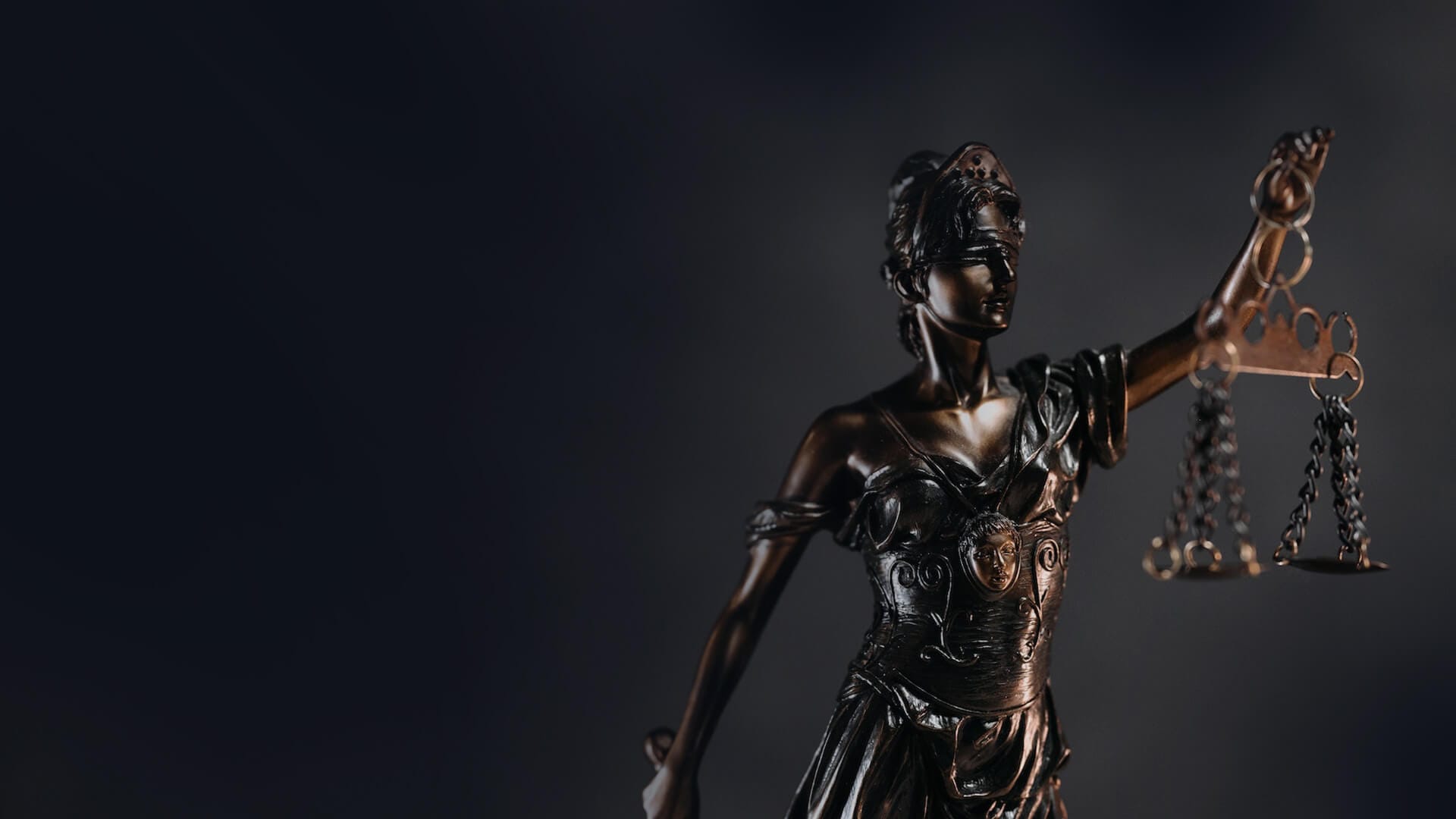 Bronze statue of Lady Justice holding scales, symbolizing fairness, legal expertise, and business law.